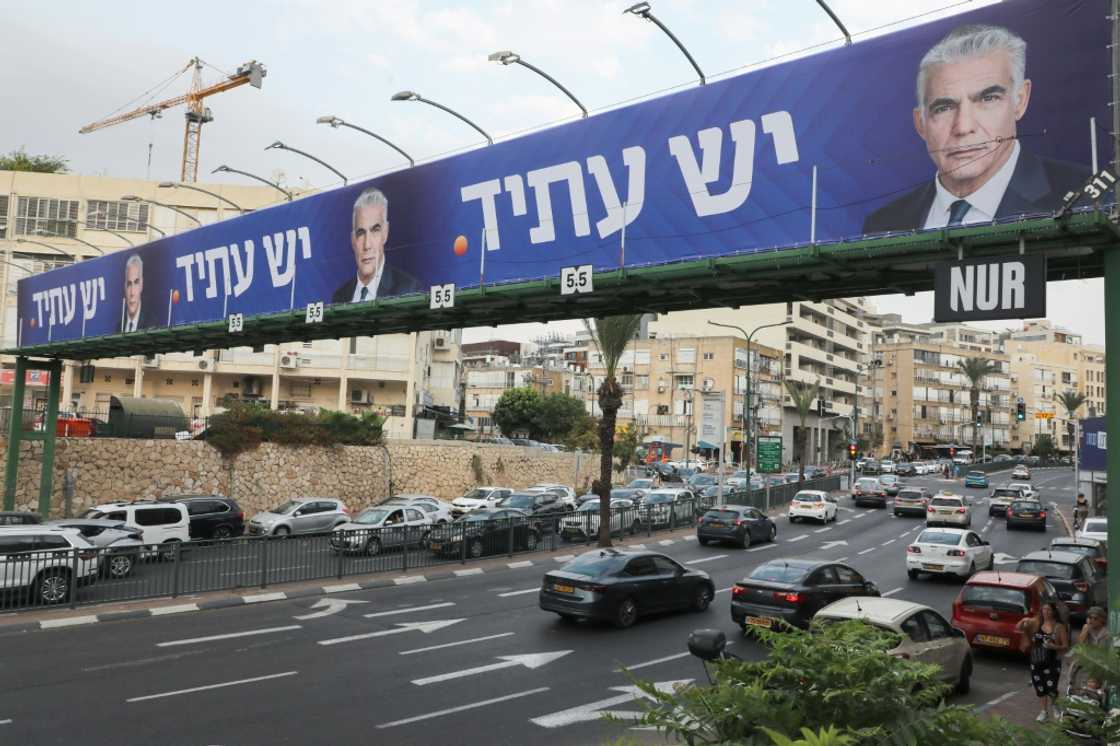 Cars drive on a highway beneath electoral billboards for Israeli caretaker Prime Minister Yair Lapid in Tel Aviv, on October 23, 2022 Cars drive on a highway beneath electoral billboards for Israeli caretaker Prime Minister Yair Lapid in Tel Aviv, on October 23, 2022