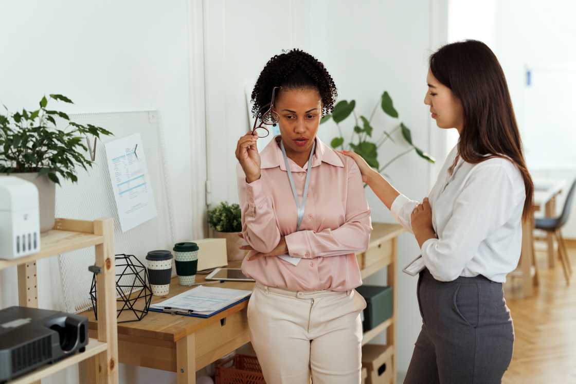 A candidate discreetly discloses information to a HR manager. A candidate discreetly discloses information to a HR manager.