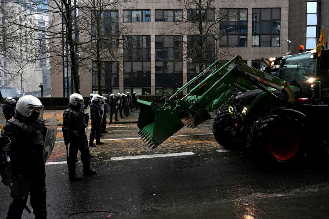 A farmer uses a tractor to force a police barrage in Brussels on February 26, 2024