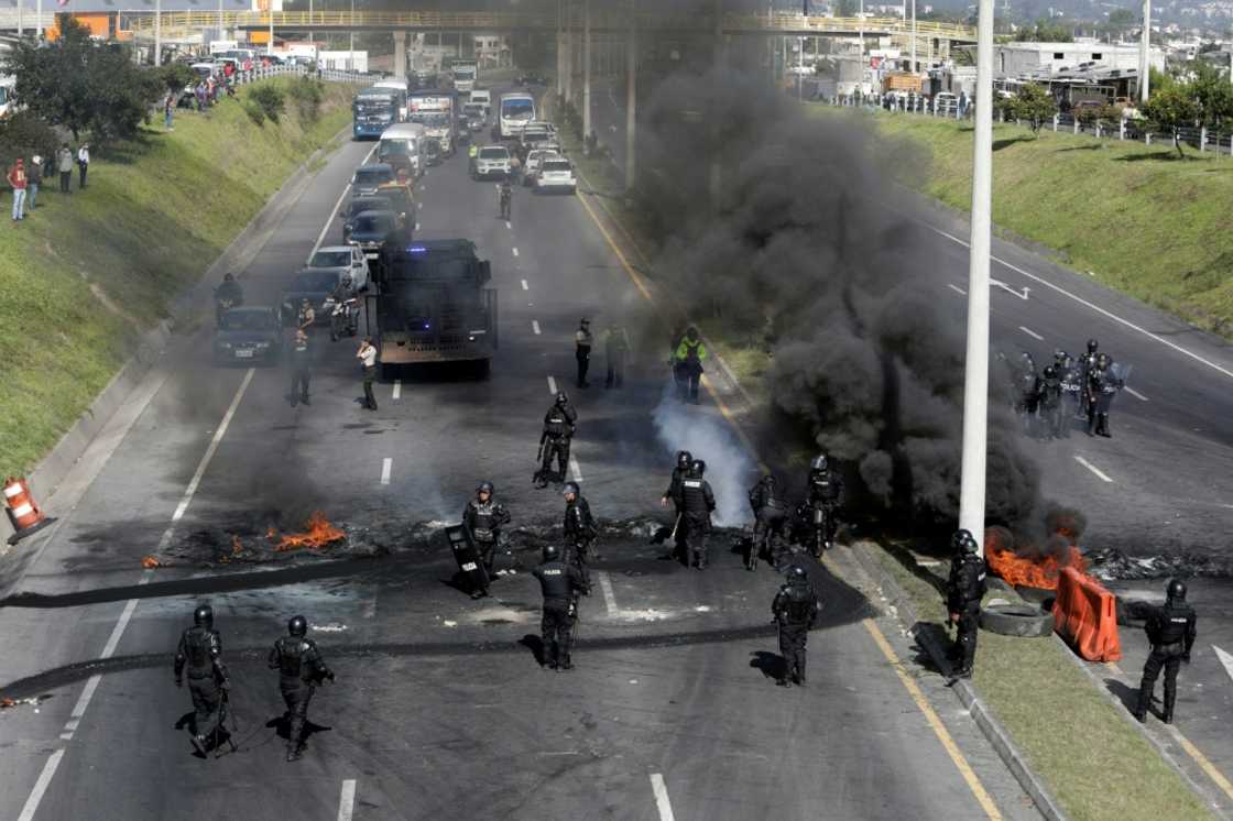 Riot police clear a blockade on the highway to Quito airport, one of Ecuador's indigenous-led protests against high fuel prices and living costs, on June 17, 2022 Riot police clear a blockade on the highway to Quito airport, one of Ecuador's indigenous-led protests against high fuel prices and living costs, on June 17, 2022