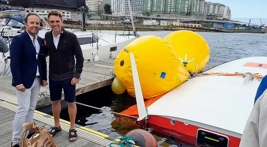 French sailor Laurent Camprubi, 62, poses with one of his rescuers after he survived 16 hours under his capsized sailboat off Spain