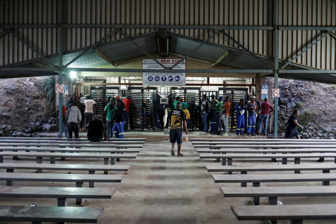 Police and security forces patrolled the area Tuesday evening as about 100 miners sang protest songs outside the mine Police and security forces patrolled the area Tuesday evening as about 100 miners sang protest songs outside the mine