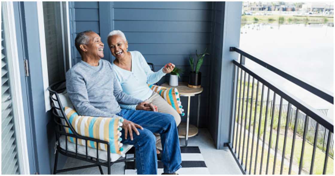 An elderly couple enjoys each other's company in their home