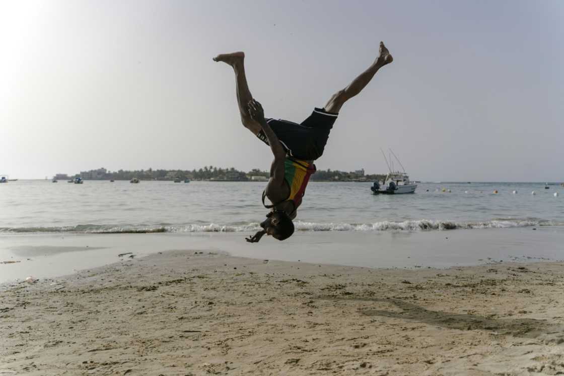 Malick, a 30-year-old acrobat from Guinea, trains on a Dakar beach Malick, a 30-year-old acrobat from Guinea, trains on a Dakar beach
