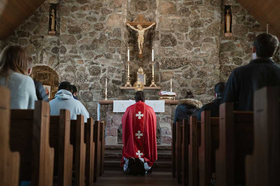 Christians are being led in prayer by the priest.