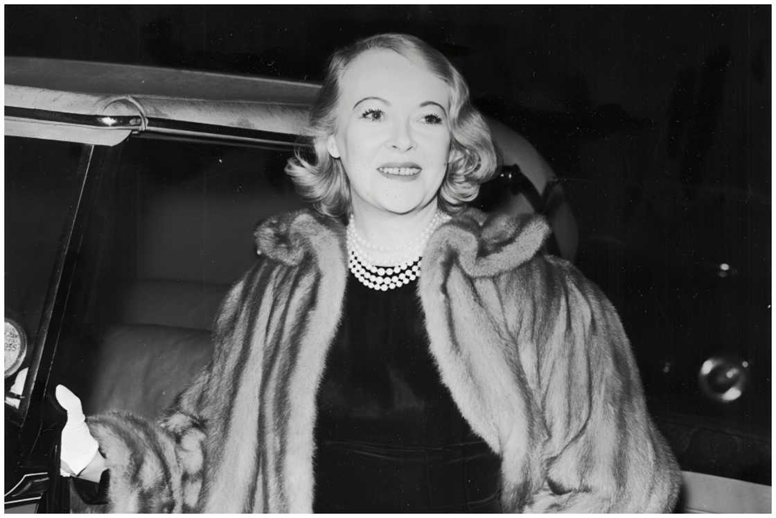 Sylvia stands next to an open car door. Sylvia stands next to an open car door.