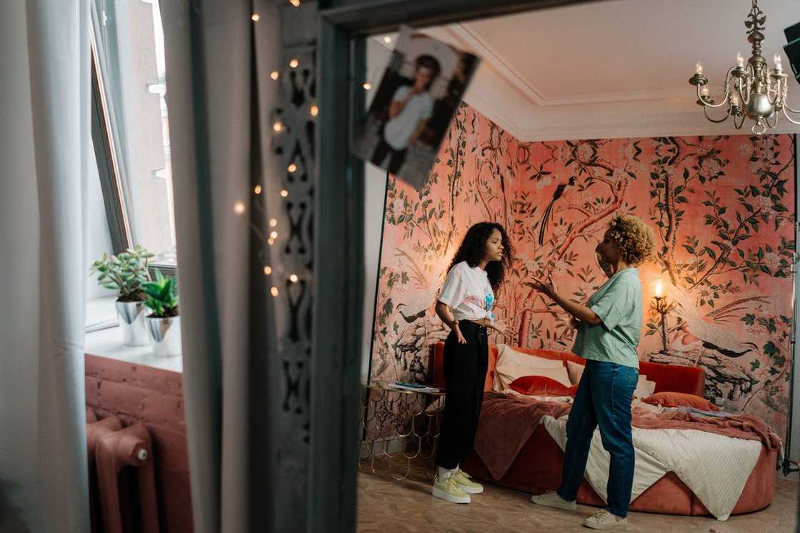 Two women argue in a bedroom.