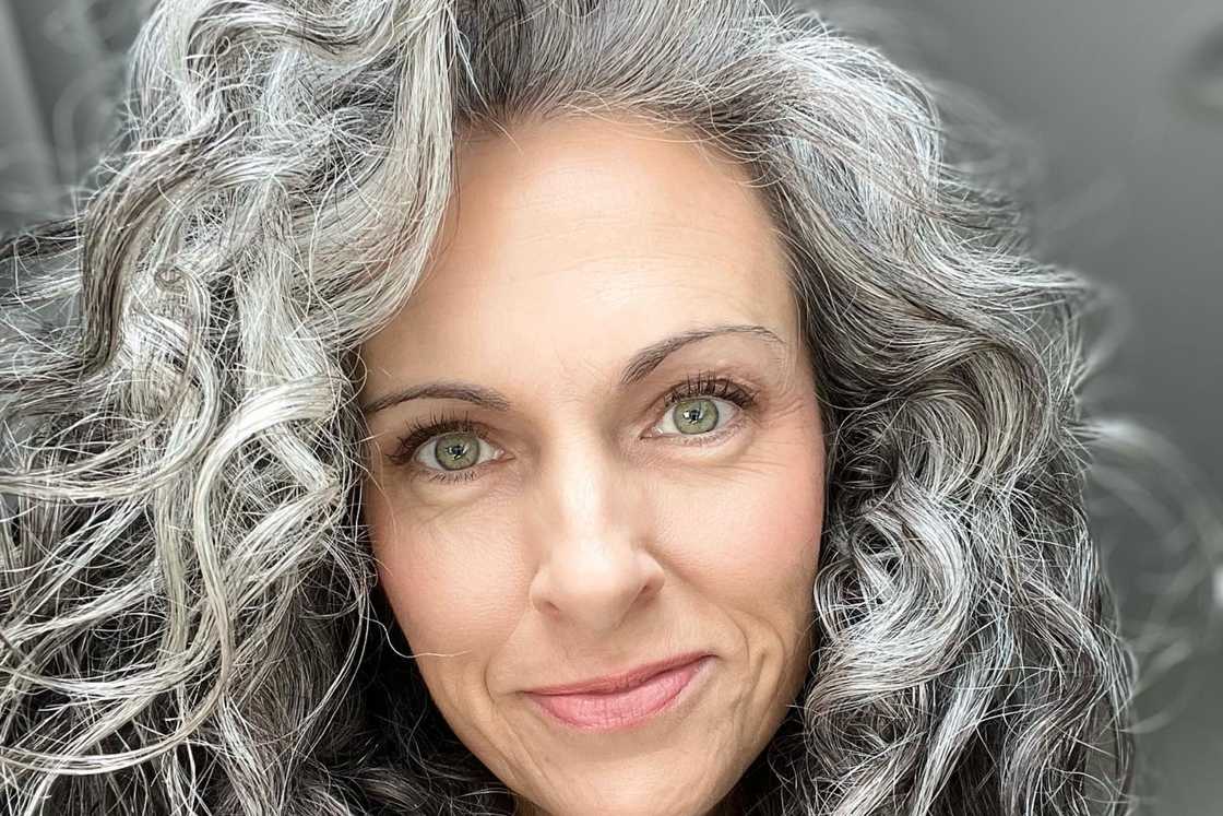 A woman shows off her loose waves with layers hairstyle A woman shows off her loose waves with layers hairstyle