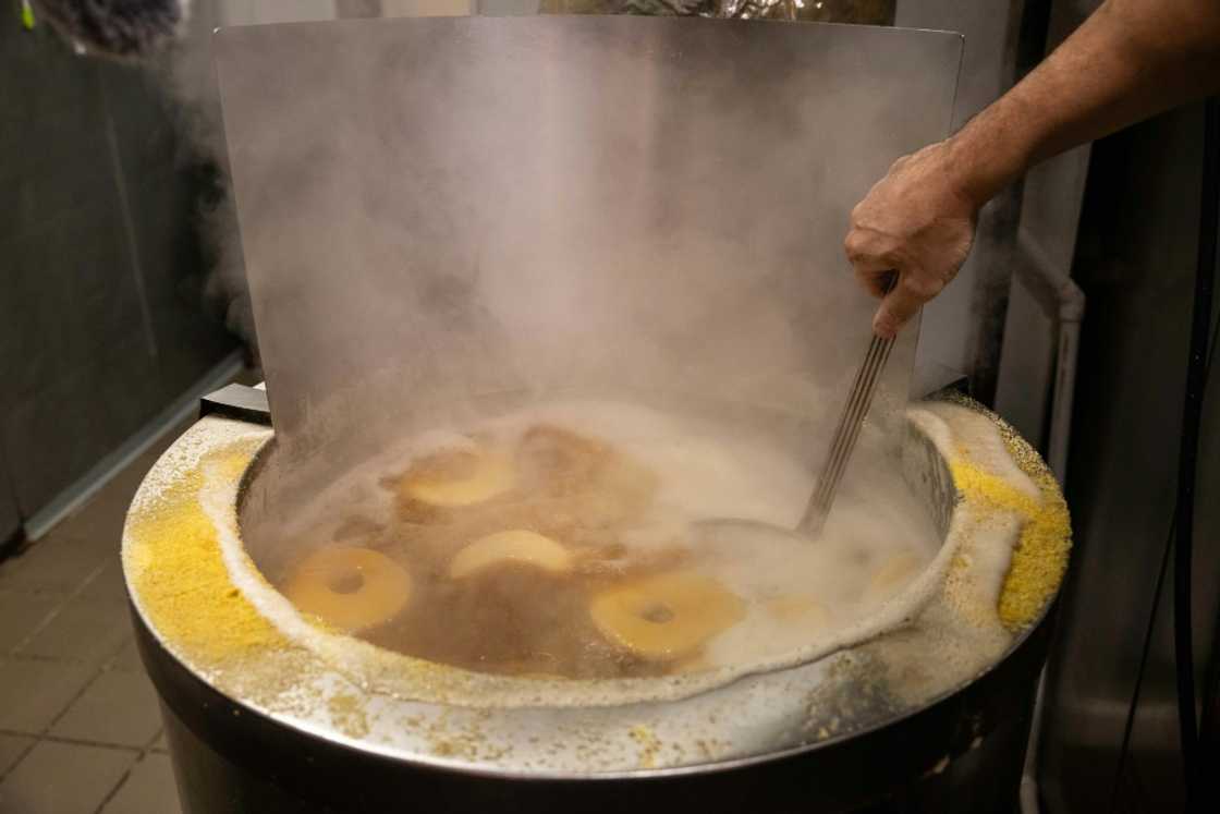Andrew Martinez boils bagel dough before the daily opening of his store in the New York borough of Harlem Andrew Martinez boils bagel dough before the daily opening of his store in the New York borough of Harlem