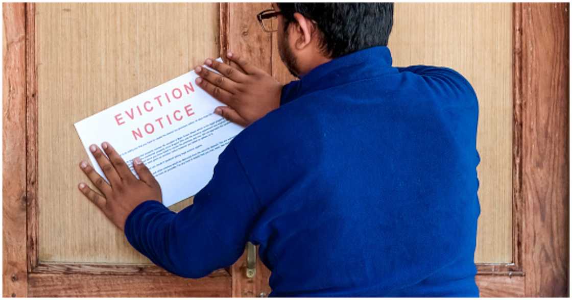 A landlord posts an eviction notice on the door of his tenant A landlord posts an eviction notice on the door of his tenant