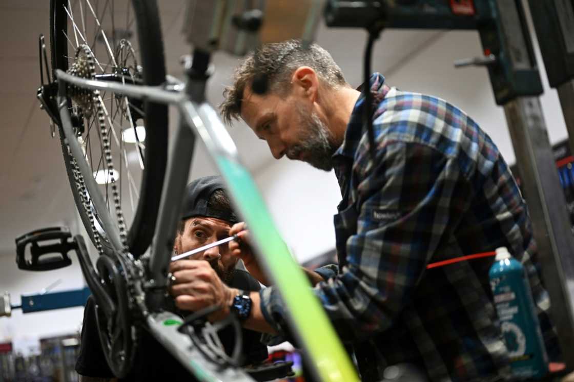 Mechanical instructor and workshop manager Nigel Brook teaches ex-prisoner Gary Oakley how to work on a bike