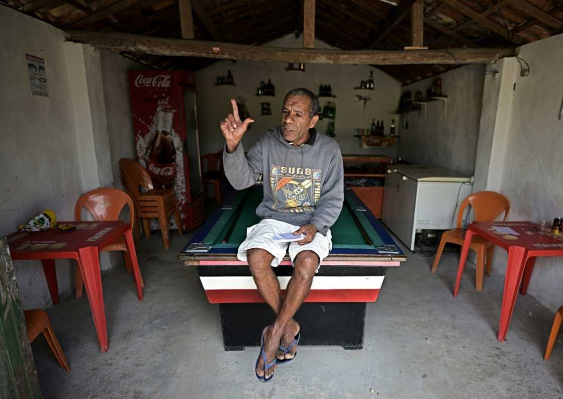 Paulo Gomes Bizerra, who lives across a dirt road from the "little house," flashes an "L" for "Lula" after belting out a song he wrote for the leftist icon Paulo Gomes Bizerra, who lives across a dirt road from the "little house," flashes an "L" for "Lula" after belting out a song he wrote for the leftist icon