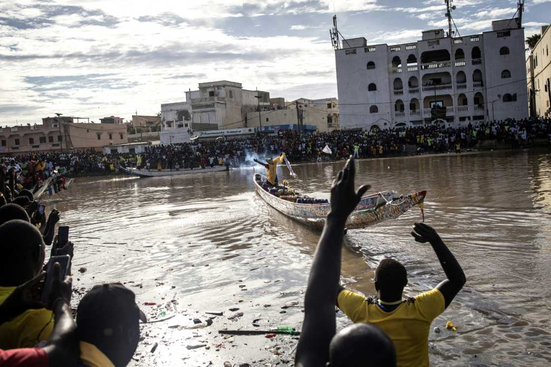By afternoon, tens of thousands of onlookers had gathered along the river By afternoon, tens of thousands of onlookers had gathered along the river