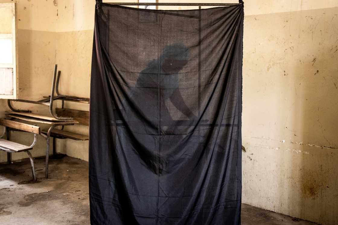 A woman chooses her voting card in Dakar on July 31 A woman chooses her voting card in Dakar on July 31