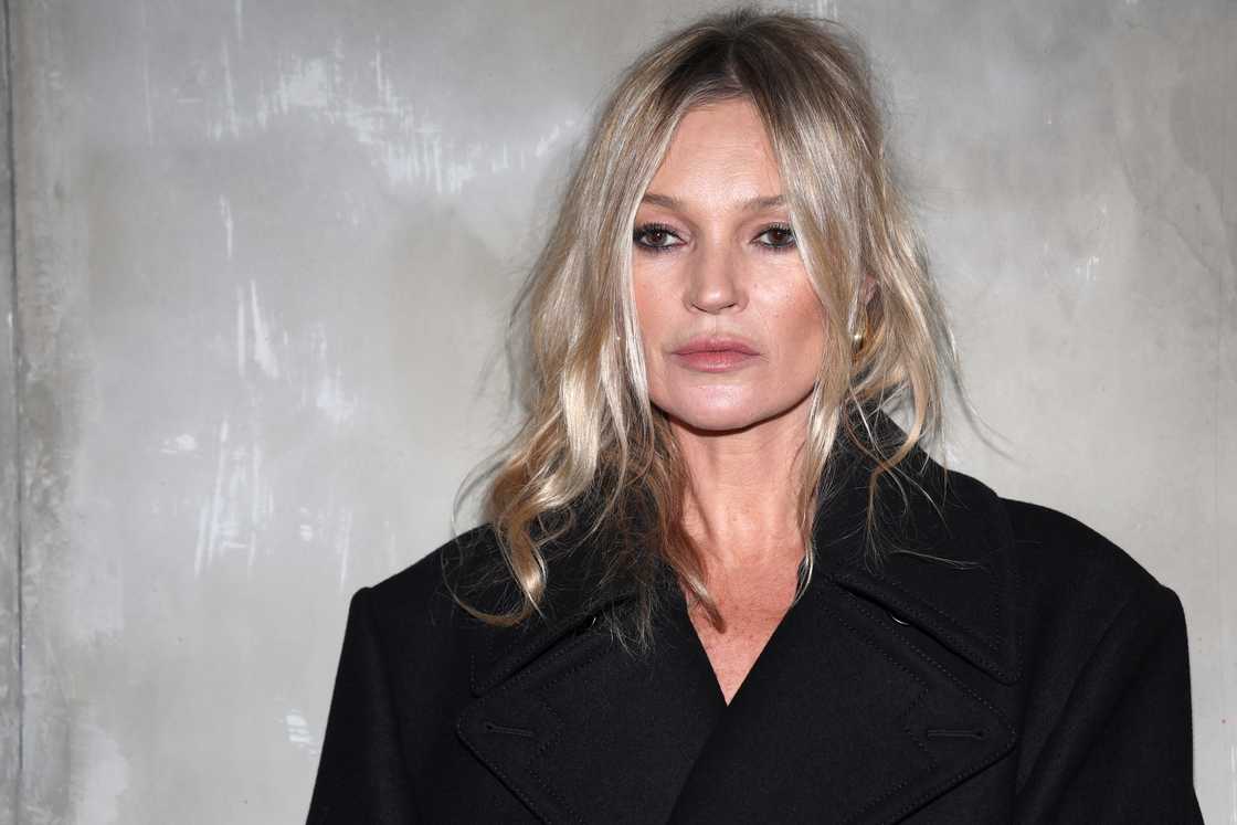 Kate Moss, in black, poses against a grey background in Milan, Italy Kate Moss, in black, poses against a grey background in Milan, Italy