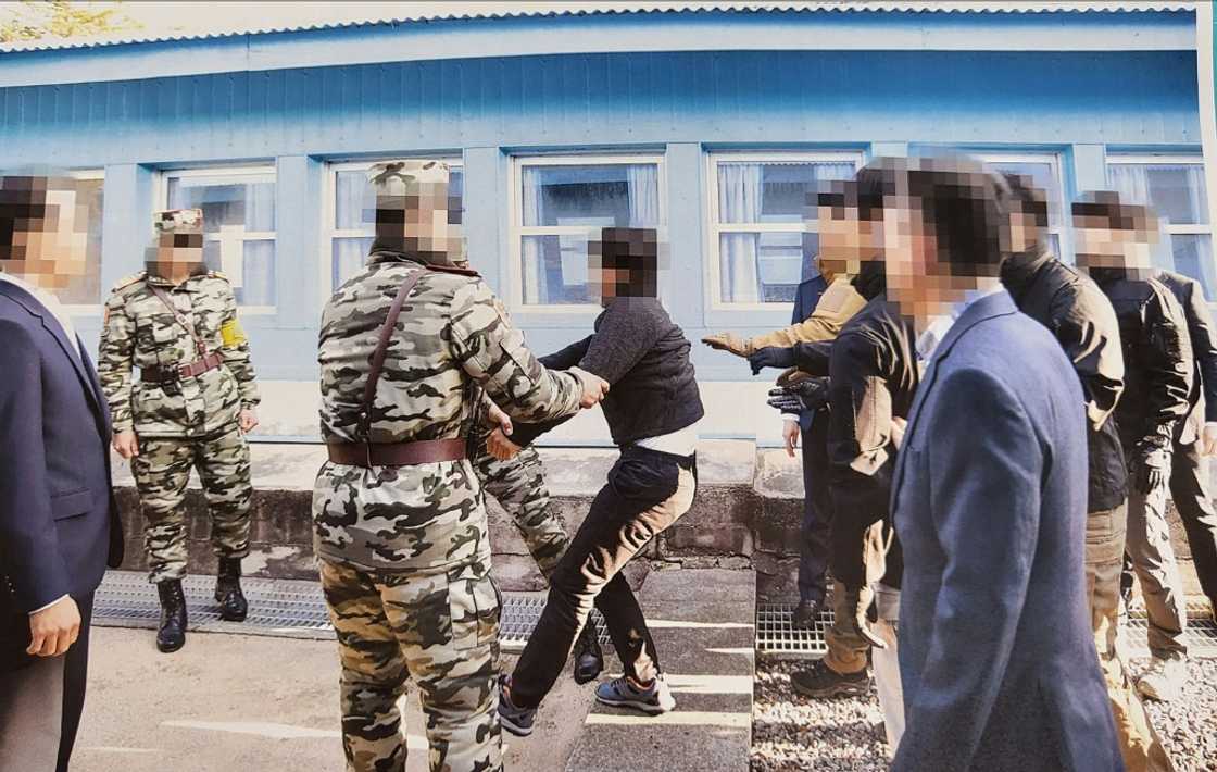One of two alleged North Korean mass murderers (C, in black) appears to resist as authorities try to hand him over to Pyongyang officials in 2019 One of two alleged North Korean mass murderers (C, in black) appears to resist as authorities try to hand him over to Pyongyang officials in 2019