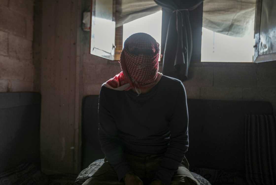 A masked captagon dealer in the Syrian city of Aleppo talks to AFP