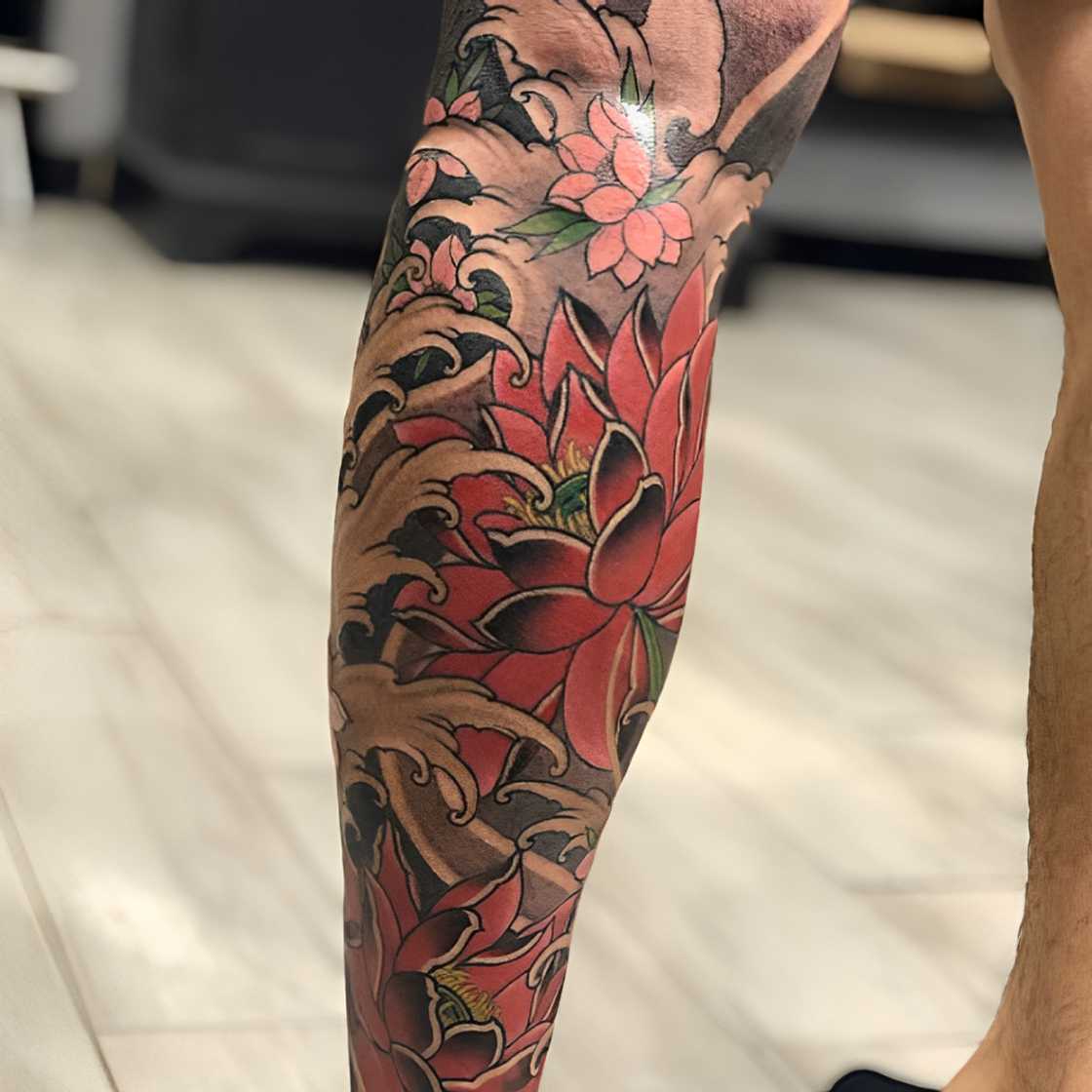 Complete half sleeve, lotus flowers, cherry blossom, and waves tattoo