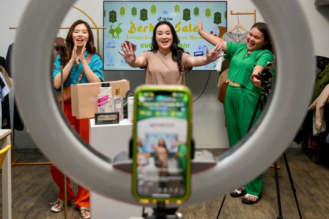Christine Febriyanti (C) is one of many Indonesians who have taken to selling merchandise on TikTok Christine Febriyanti (C) is one of many Indonesians who have taken to selling merchandise on TikTok