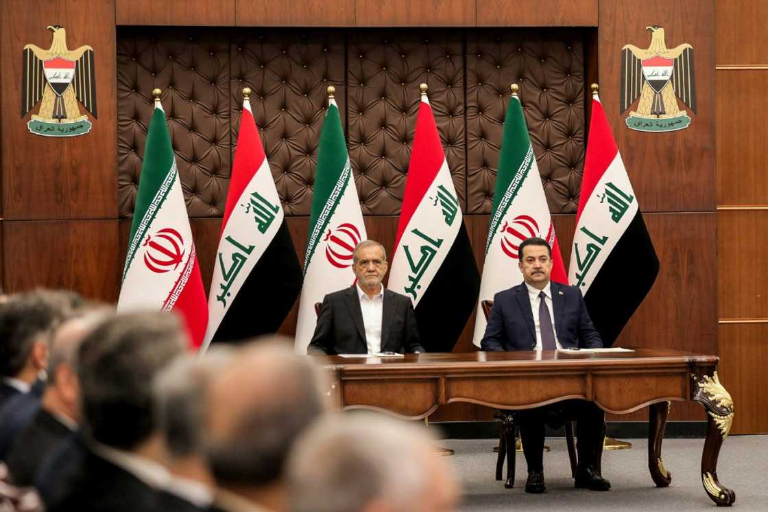 Iraqi Prime Minister Mohammed Shia al-Sudani (R) and Iranian President Masoud Pezeshkian attend a ceremony for the signing of memoranda of understanding in Baghdad