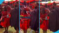 Reverend Obofuor sprays numerous GH₵100 notes on his daughter at his late mother's one-week observance