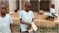 Kid hawking plantain does his school assignment by roadside in moving video