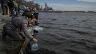 Kherson residents seek water and phone service on river's edge