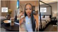 Lady shows off the gorgeous interior of her apartment with nice lamps, couches and glass flower vases