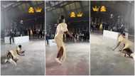 Video shows moment lady in long dress fell awkwardly while dancing at event; quickly picks herself up