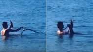 The booze will not fall: Man boldly fights snake in ocean, doesn’t spill a drop of drink; many react to his video