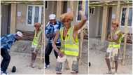 Young man approaches labourer on construction site, plays music and asks him to dance in funny video