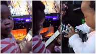 Reactions as little kid looks for Wizkid's song essence on adult's phone herself, plays it in viral video