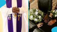 Priest falls on a coffin in a grave while praying for the dead