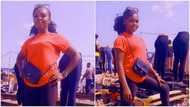 Pretty young lady with no job sets up at roadside to sell second-hand clothes