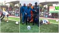 Nana Addo kicks a football as he commissioned the Alajo astroturf facility and got people applauding him