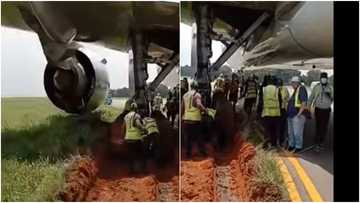 Plane gets stuck in mud while preparing to take off, video shows officials using shovel to clear it