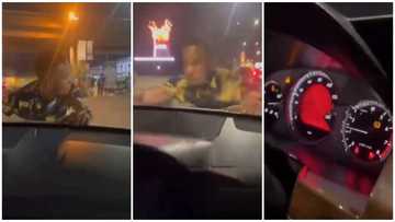 Stubborn man hangs on to bonnet of moving car after lady refused to give him cash, video goes viral