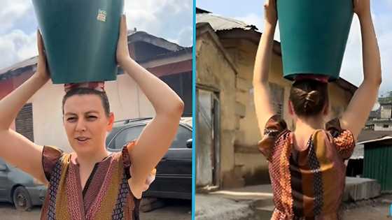 Obroni lady in Ghana carries a bucket of water on her head like a common Ghanaian