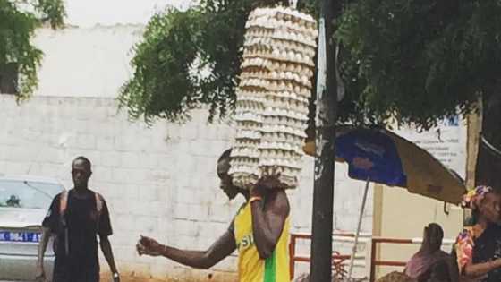 Man Walks on Wet Ground While Carrying Loads of Eggs on One Arm