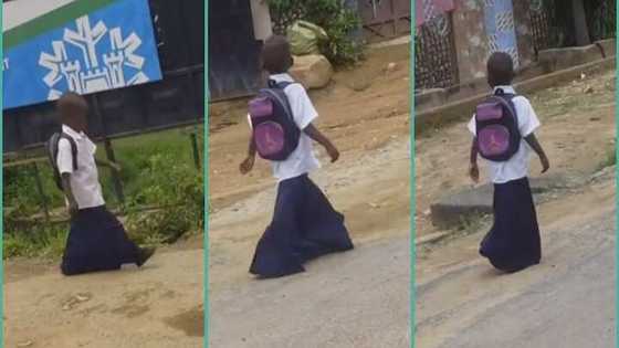 Primary school girl walks on the road in oversized uniform, trends: "She will wear it till SHS 3"