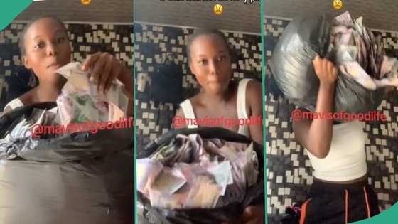 "I wan go buy land for village": Nigerian lady shows off money she picked at club, fills them in bag