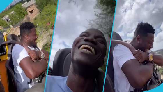 Asamoah Gyan screams, closes his eyes hard while on a roller coaster ride in the US